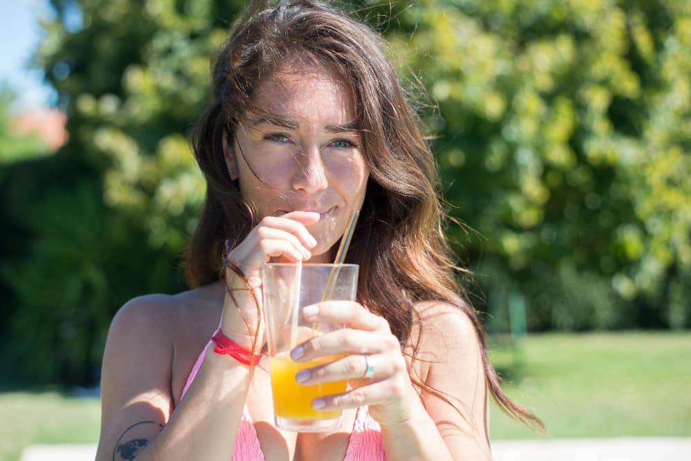 Delicious Taste Experience - Woman Enjoying Refreshing Orange Juice Outdoors